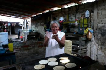 Raquel's Family House in Zacatecoluca, El Salvador.  There's abuela, making stacks and stacks of tortillas for pupusas, she sells them to the pupusarias around town. In El Salvador, the tortillas are more like pitas than the thin, flat Mexican style. They make them thick enough to split apart and you stuff whatever food you want in there!
