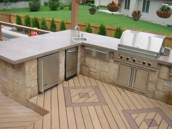 This outdoor kitchen boasts a sink with hot and cold running water a garbage disposal, ice maker, refrigerator and viking grill with rotisserie and a double burner on the right side of the grill Custom trex deck with inlay patterns and pergola all complemented by 12 volt lighting for just the right evening touch

