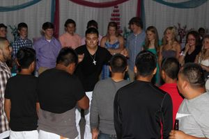 Guests Forming a Circle Around a Single Guest in the Middle at a Quinceañera