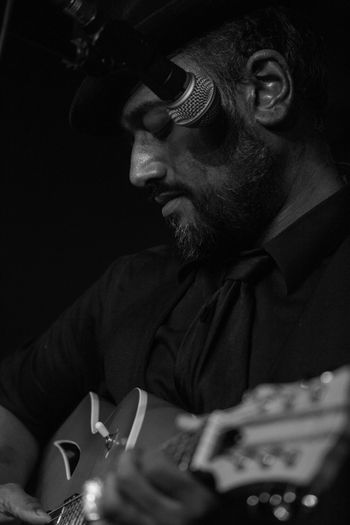 Meet Tariq Anwar, our featured artist on May 1st! Tariq Anwar's musical journey began in 2012, with a handful of songs at a handful of open mics in his hometown of Ottawa. His style does not fall easily into any single category, often straddling the lines between folk, grunge and blues. He combines guitars, a rhythm stomp box and harmonicas with a unique voice that can start out sweetly soft and then turn on a dime into a spine-melting scream. He writes songs about personal struggles and observations of downtown urban life. Tariq is the resident musician at Atomic Rooster, playing every Wednesday night since 2016.
