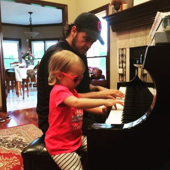 Paul teaching piano to his daughter
