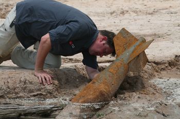 Bomb disposal specialist Laith Stevens examines live bomb behind school, Savannakhet, Laos
