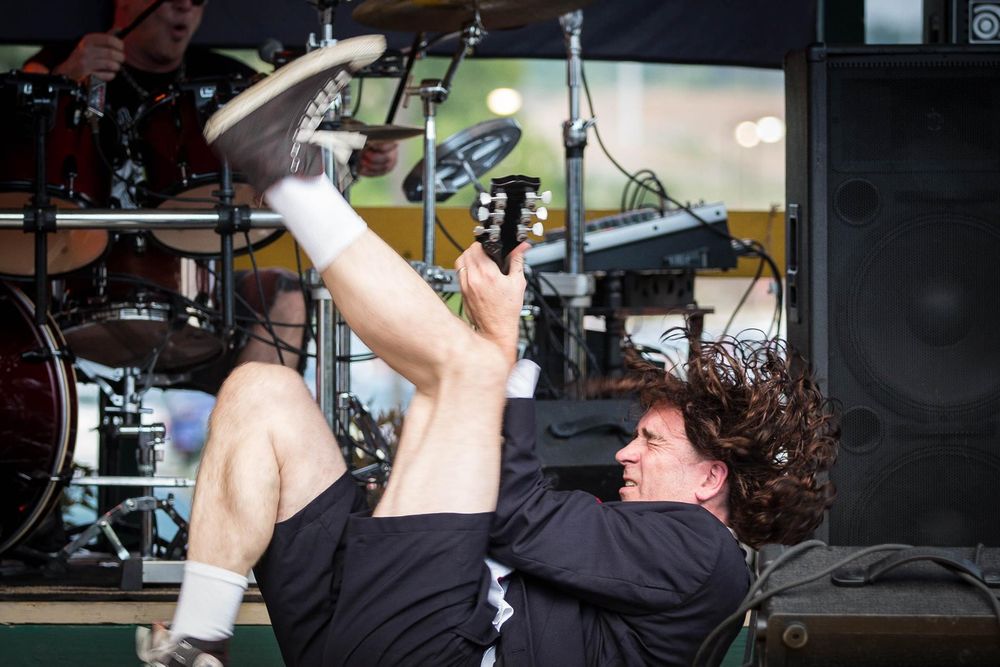 guitar teacher Jay Albert performing as Angus Young flailing on his back