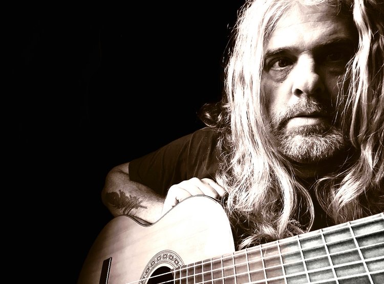 closeup of Tod Weidner in sepia tones with acoustic guitar
