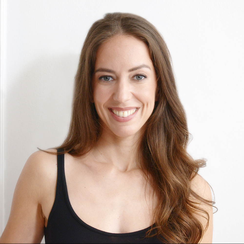 Sophie Lukacs, profile photo, long wavy brown hair, blue eyes, smiling, black tank top