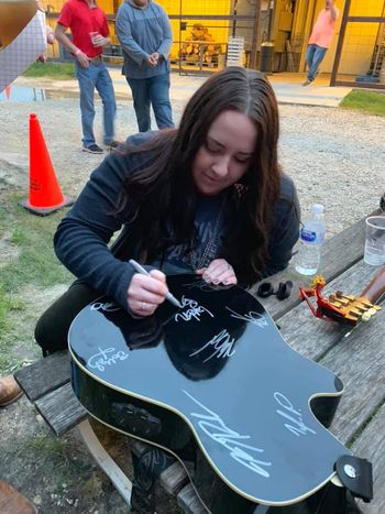 Signing a guitar at Stache Bash in Gatesville
