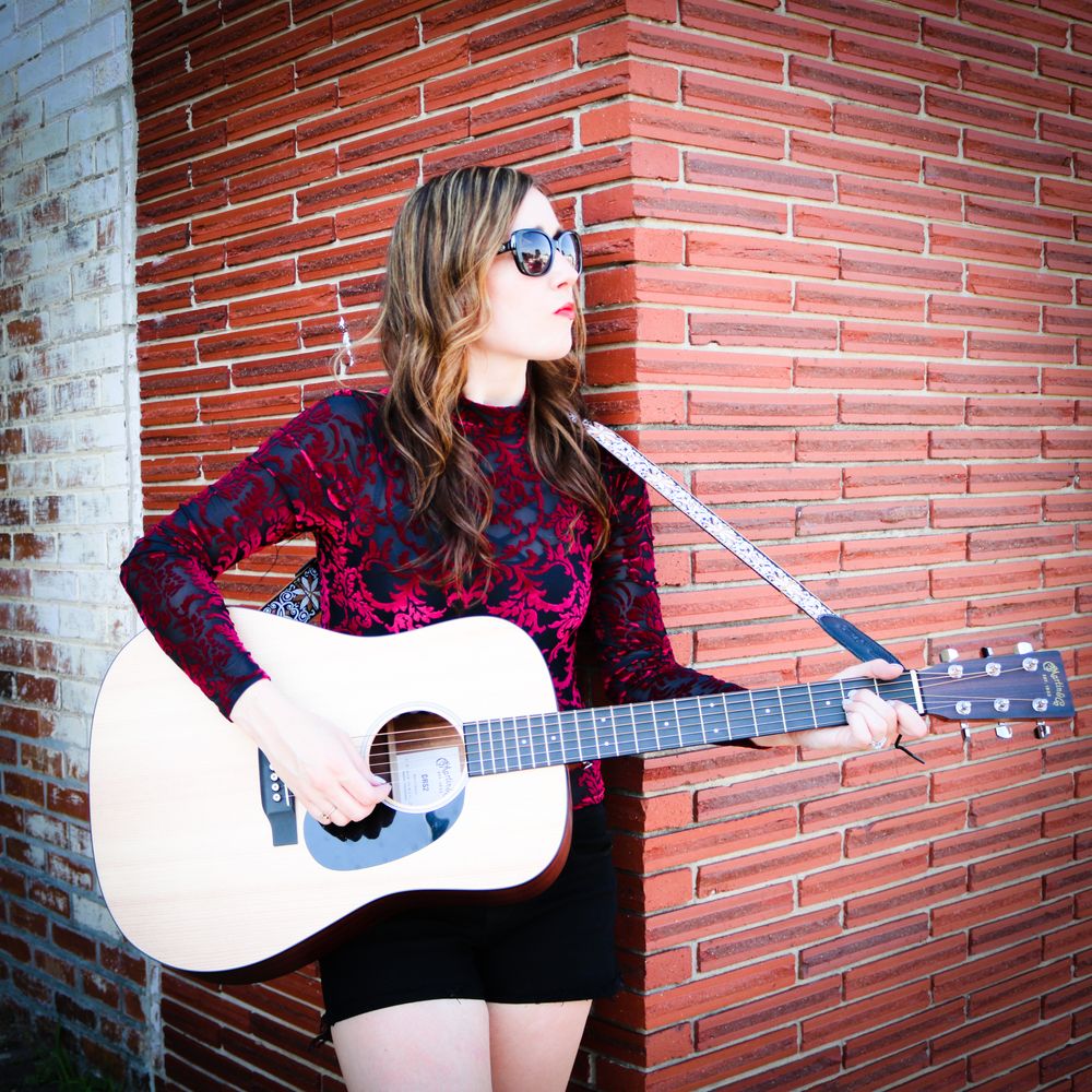 Girl looking to the side while holding guitar