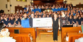 Massed Choirs with the final total cheque.
