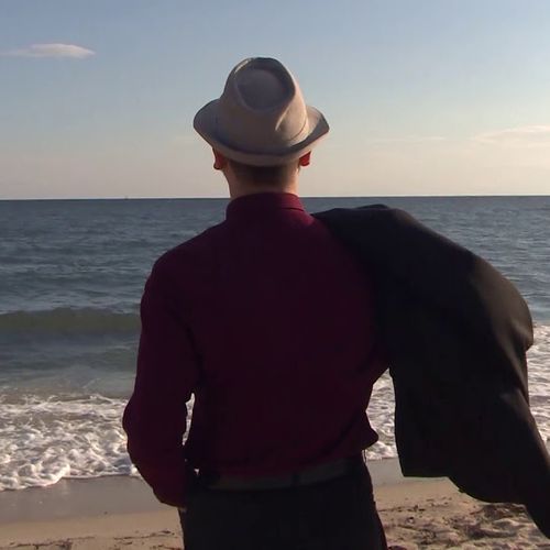 Snippet del video "come ti sentiresti" con Giacomo Deiana di spalle in riva al mare di Cagliari.
