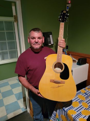 Trent holds a guitar signed by Trace Adkins

