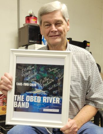 Host of the Buck Creek Ranch show series, Allen Snow shows off the band's  signed copy of their first International album release.
