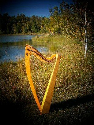 Francesca Reuben's Steen harp made by Stephen Green, by the lake in Northern, MN with birch tree in the background
