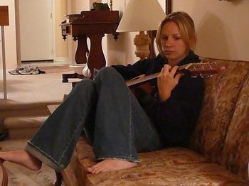 Julie plays a chord or two, chillin' on the couch.
