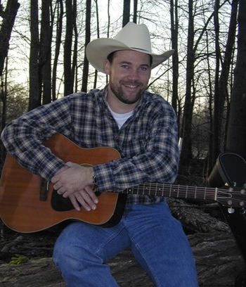 Sitting on Log with Guitar
