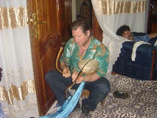 Derrik gets aquainted with the riity (Senegalese one string fiddle) at Massamba's house in Dakar, Senegal
