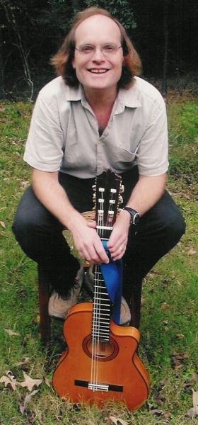 Tom sitting on the stool with guitar Let's play!
