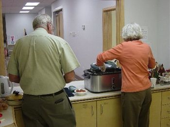 Mr. Don and Ms. Pam prepare to serve:
