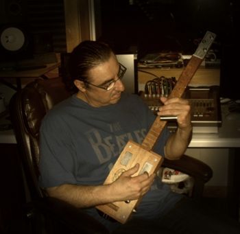MC in studio playing a three string Cigar Box Guitar custom made by Mick Kay. May 31, 2011
