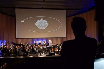 The composer (in silhouette) watches the dress rehearsal (Photo Credit: NASA/Wade Sisler)
