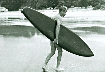 Ross on a coolish summer day at Waipu Cove ...January 1960 Ross carrying Dons unfinished board after trying it out (without any wax)....How good is the shape of that board for a 1960 model...impressive!!...
