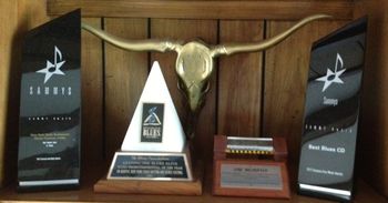 Various awards  (L to R) -  a SAMMY (Syracuse Area Music Award) for the New York State Blues Festival, my Keeping the Blues Alive Award from the Blues Foundation, another SAMMY for Best Blues CD for my A History of Blues 4-CD box set, and a community award for service to music and the arts from the Syracuse Convention and Visitors Center.
