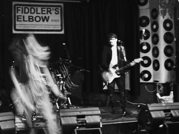Hats Off Gentlemen It's Adequate photo by Michael Young Speed demon Ibon in full demonic frenzy as a ghostly Malcolm looks on while playing a solitary chord. Fiddler's Elbow Save The Children gig Jan 2016
