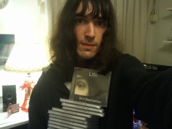 Holding CDs Amil Baymashkin Holding Copies of LIfe
