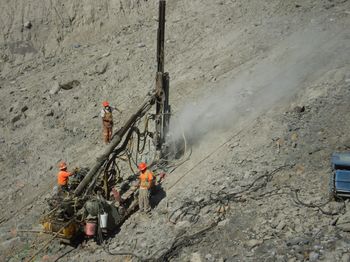 The staircases were designed with no adjustment between the mounting posts and the the staircase frames, so they required a precise placement of the mounting posts to a tolerance of 1 mm.  Another costly design flaw.  We tried to drill holes in the rock with an AirTrack drill attached to my D8 winch line, but it proved impossible to get precise enough on the steep slope … all it would have taken was to design some tolerance into the connection between the posts and the staircase frame.
