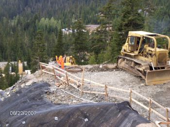 D8K angle dozer with Carco J120 inching winch.  We normally ran 35 mm winch cable for train wrecks where it was short, heavy pulls, but here we needed long pulls and it was only a 120 hoe so by going to 19 mm cable we could get the 550 feet of line we needed to reach down the hill.  By the time the hoe was very far down the hill I could no longer see him over the crest of the profile, so radio communications were required, which was a challenge at times when radio traffic got busy.
