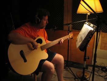 Dan playing the acoustic bass guitar in the recording studio

