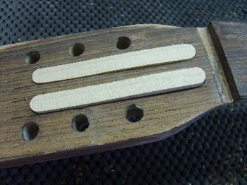 The splints bridge the crack repair, and will spread the string tension throughout the headstock.
