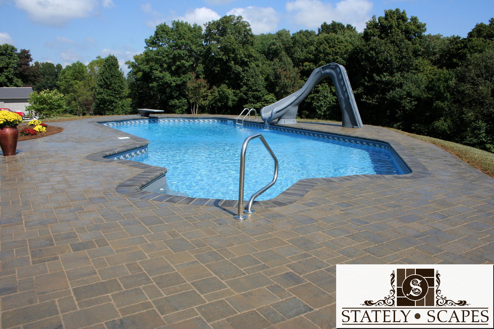 Matrix swimming pool with slide and Belgard Urbana paver patio.