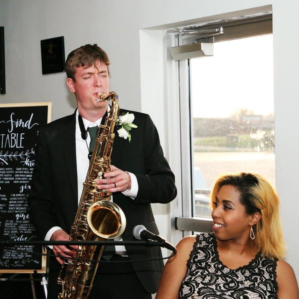 Kimberly Alana singing and playing piano at a wedding with a saxophone player
