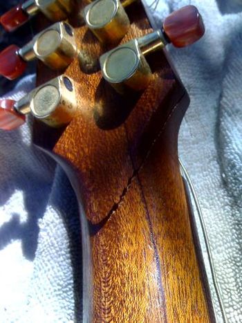 Ouch! A knocked over guitar often results in a cracked or broken headstock.
