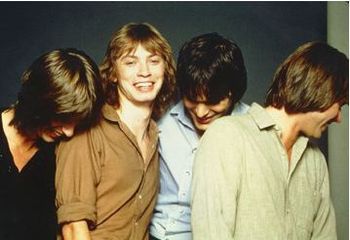 The photographer asks the band to stop smiling...and gets the opposite effect.
