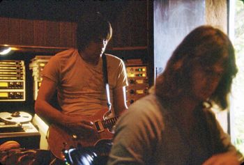 Gary plays a guitar part as Mike Stone twittles at the console. Note the door to the outside is left open to allow in some sunlight from the front yard.
