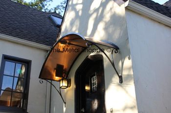 Arched Copper Awning over doorway. Iron frame and custom iron scroll accents. Location: Oakland, CA
