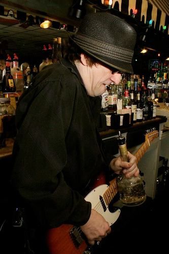 Dave plays guitar with a liquor bottle at R Bar in Dormont.

