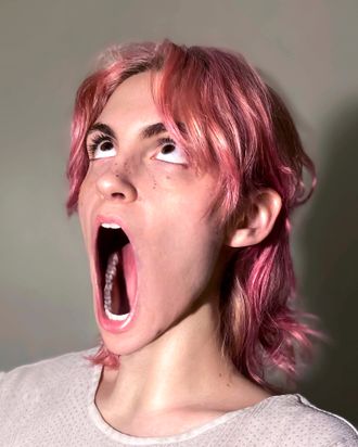 Medusa, non-binary musician; pop artist; rapper; hip-hop artist; pink hair, looking up; jaw unhinged, revealing extra teeth.