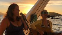 Lauren and Kerrin singing harmony on a sunset sail