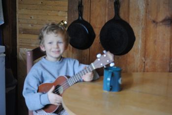 Evan, sitting at the table, playing the uke...
