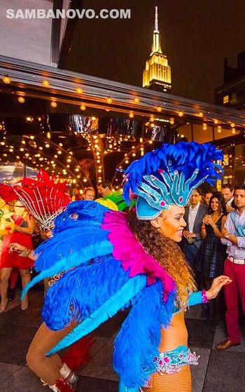 One of our many samba dancers in New York for hire at an outdoor event with the Empire State Building in the background
