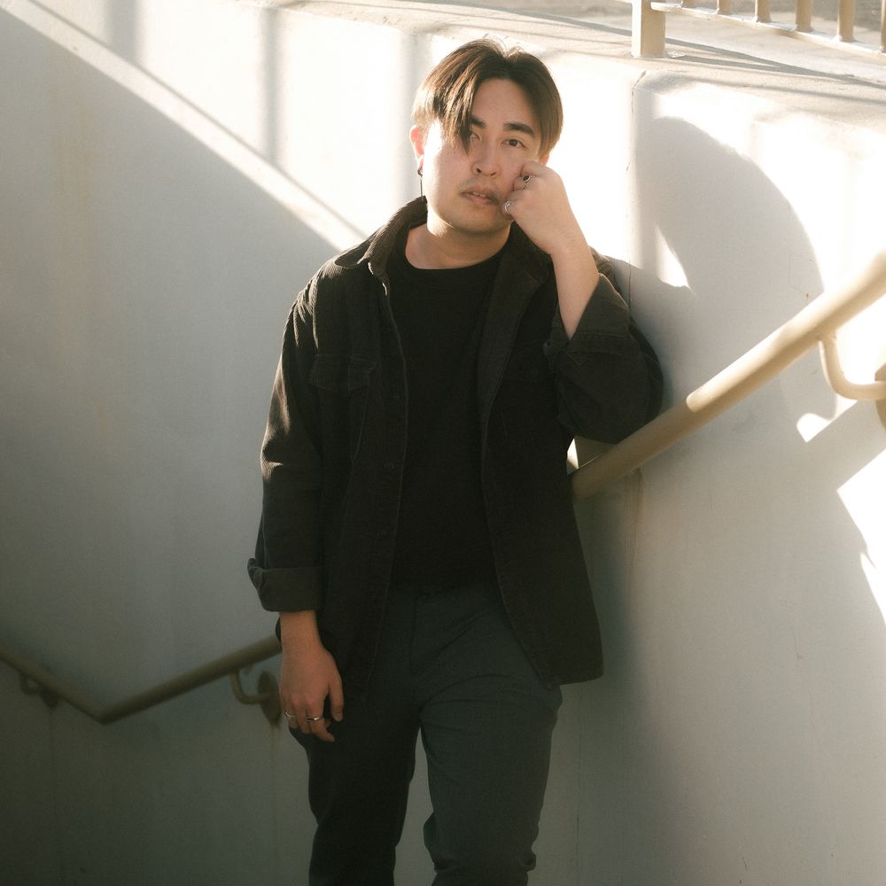 Man leaning against sunlit staircase