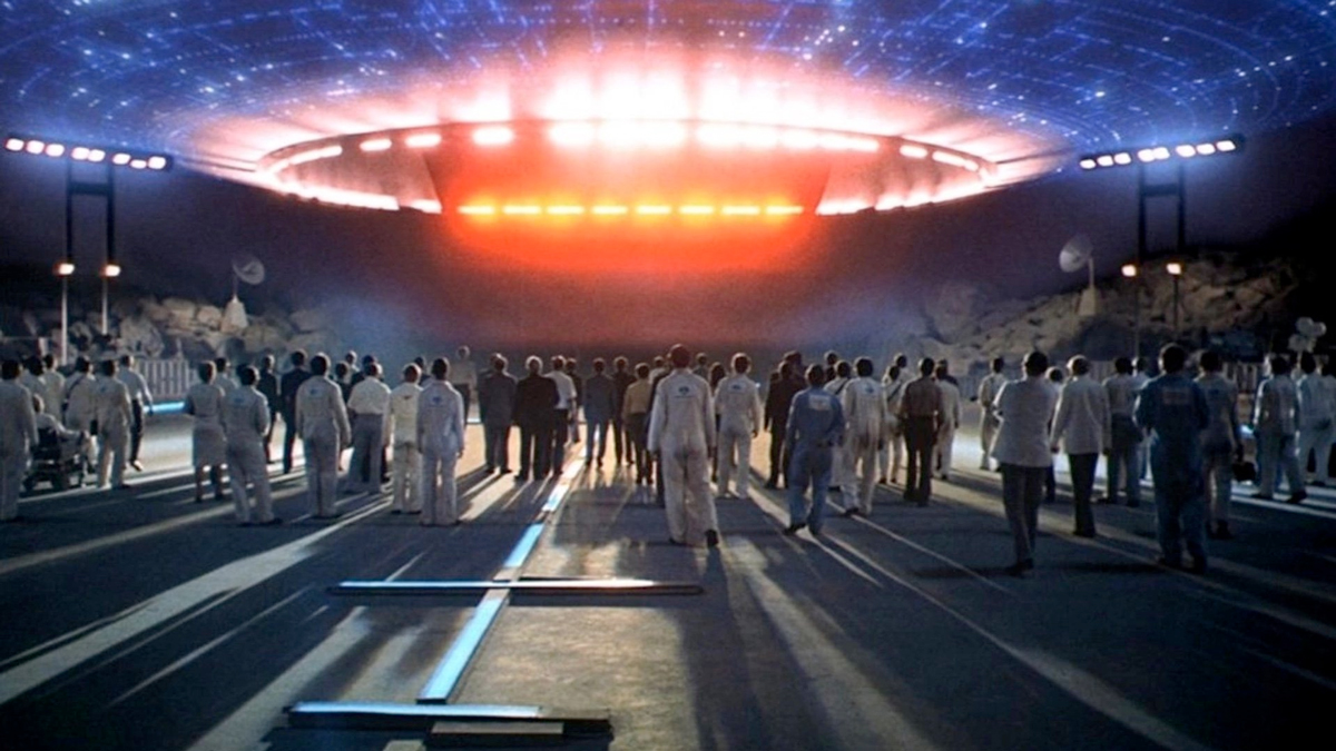 Image from the movie Close Encounters showing the underside of the mothership hovering over a crowd of people.