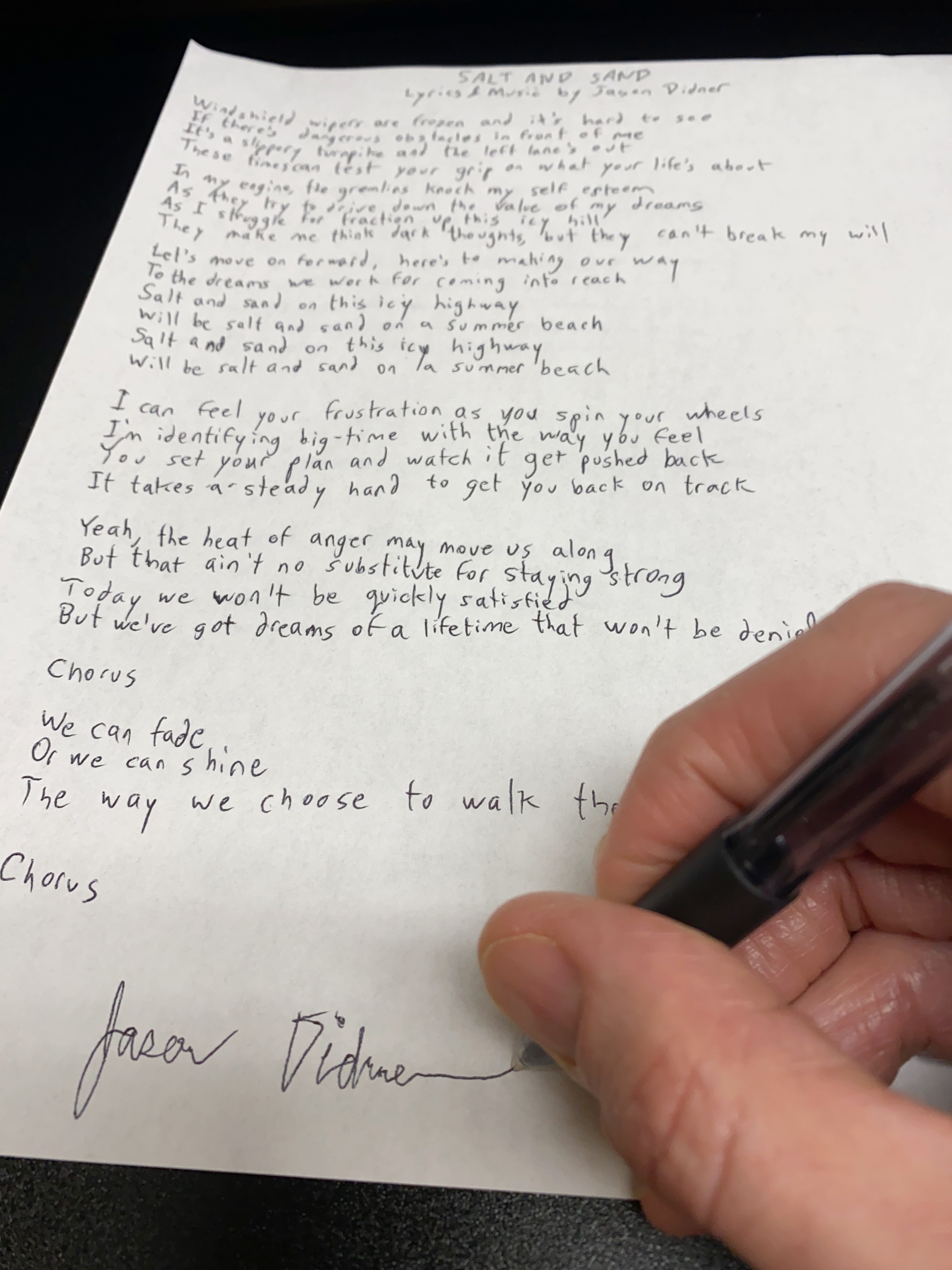 Jason Didner signs his lyric sheet for his song 