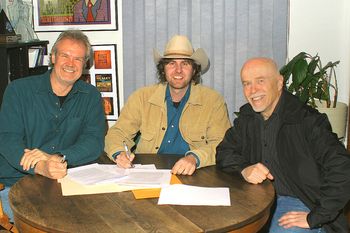 Tim signing his recording contract with Holger Peterson and Alvin Jahns of Stony Plain Records
