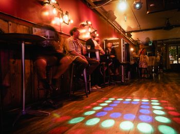 people sitting a chairs around the dance floor
