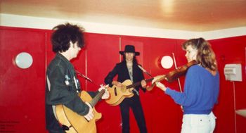 Oslo, Norway, 1988 Sardines dressing room. Marc Moreland, Andy Prieboy, and guest violinist, Laurie Kempen run through Wrong Way to Hollywood. Photo by Gail Holland
