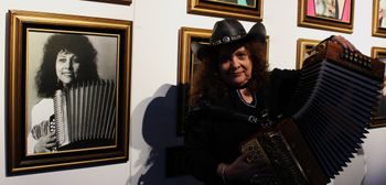 Eva pictured next to her photo on display at the Tejano Conjunto Hall of Fame and Museum exhibit at the San Benito Cultural Heritage Museum. Ybarra is a 2009 inductee. (2022)
