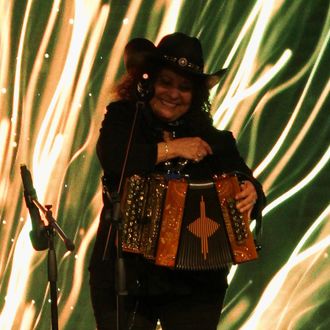 Eva Ybarra playing her accordion on stage.